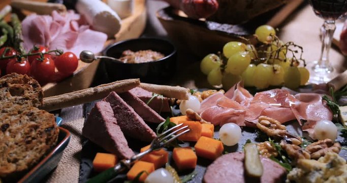 Dolly close up view of a platter of cured meat (charcuterie), ham, salami, pate and cheese