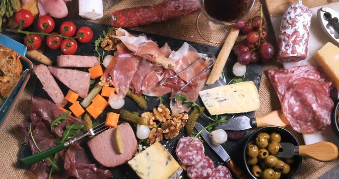 Dolly bird eye view of a platter of cured meat (charcuterie), ham, salami, pate and cheese