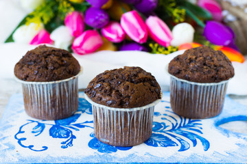 Three chocolate muffins on a flowers background