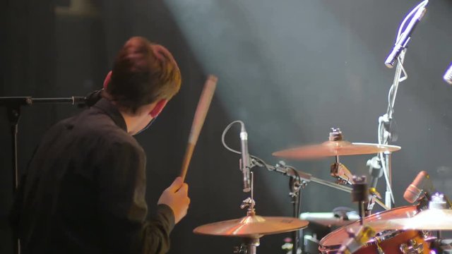 Young drummer playing on a concert on a drum set