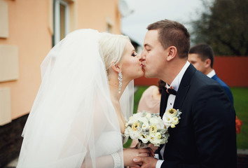 Beautiful kissing newlyweds outside