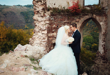 Beautiful stylish newlyweds posing outside