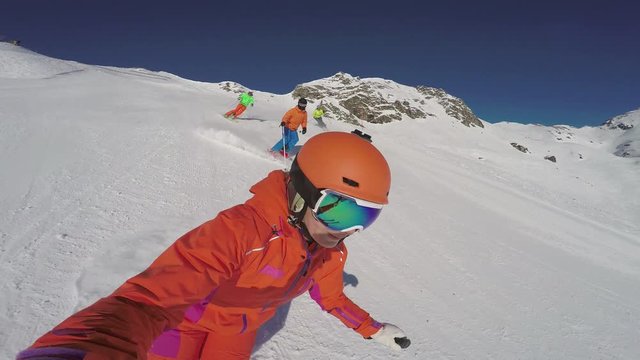 4k footage, selfie point of view skiers skiing on ski slope on sunny winter vacation day with blue sky
