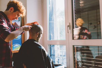 Woman barber cutting hair using razor - beauty, hair style concept