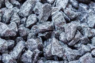 Decorative dark pebbles, like coal, close-up, background, texture. For modern abstract pattern, wallpaper or banner design