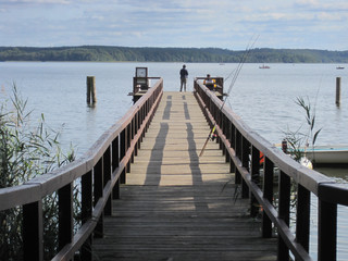 Naklejka premium Bootssteg mit Anglern am Plauer see