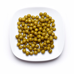Peas on a white saucer isolated on white.