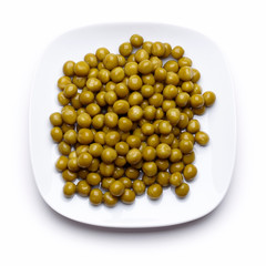 Peas on a white saucer isolated on white.