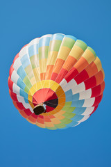 Hot air balloon, colorful aerostat on blue sky, low angle view
