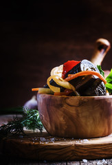 Marinated eggplant with onions and peppers in a bowl, vintage wo