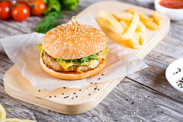 burger with mushrooms and chop on a wooden stand