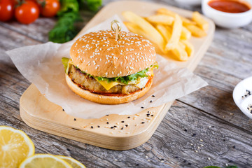 burger with mushrooms and chop on a wooden stand