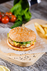 burger with mushrooms and chop on a wooden stand