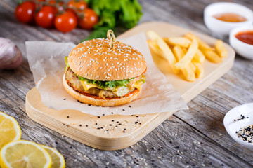 burger with mushrooms and chop on a wooden stand