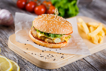 burger with mushrooms and chop on a wooden stand