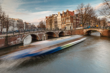 Fototapeta na wymiar Amsterdam Keizersgracht a tour bout is passing by through the canal