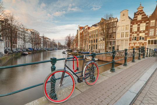 Red bicycle parked against the bridge railing at the Keizersgracht at Amsterdam 