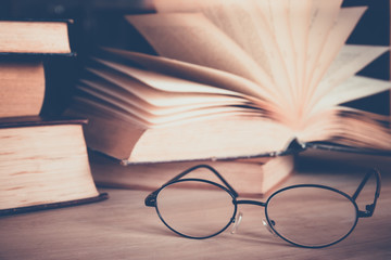 Book with glasses on table, vintage picture style