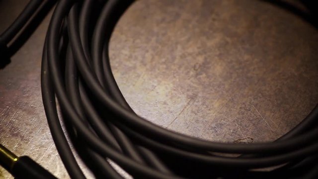 Close up dolly video of a a rolled up cable with jacks.