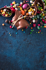 Delicious chocolate easter eggs ,bunny and sweets on dark blue background