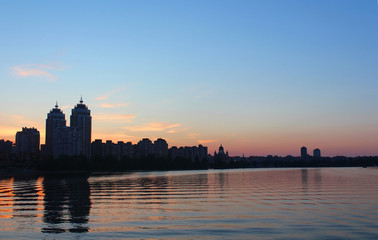Fototapeta na wymiar Obolon skyline near the Dniepro river in Kyiv. It is sunset time
