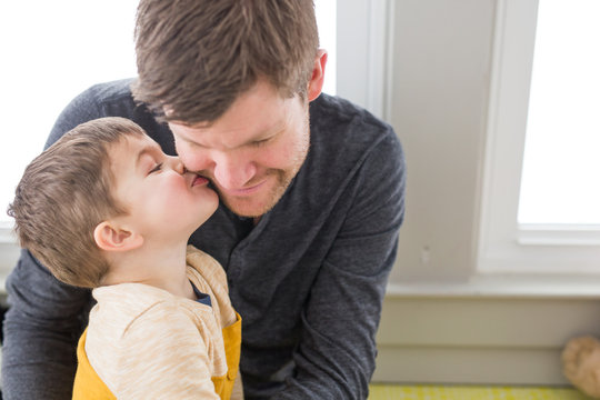 Young boy kissing father on cheek