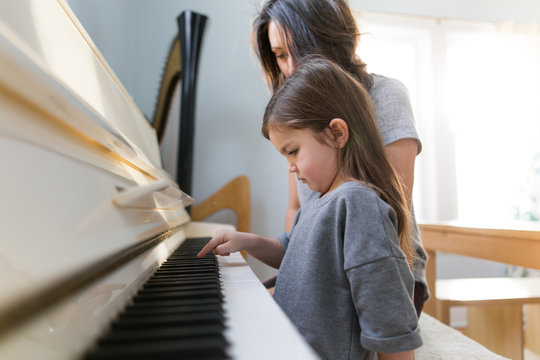 Girl and woman playing piano 