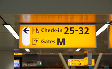 Illuminated sign with gate number and check-in desks