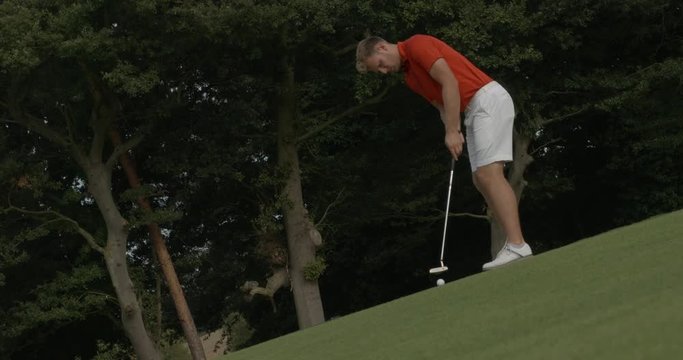 Golfer sinks putt.