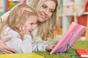 mother with little daughter  reading 
