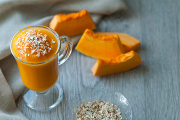 pumpkin smoothies, vitamin drink for breakfast. On a wooden background.