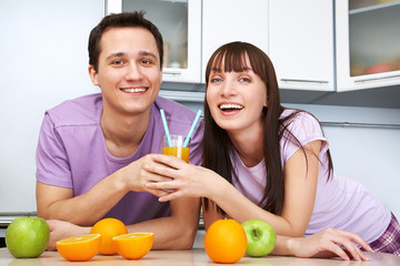 couple drinking orange juice in the kitchen