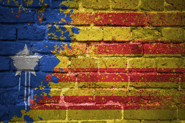 painted national flag of catalonia on a brick wall