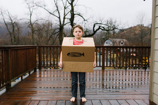 Young boy wears cardboard box 