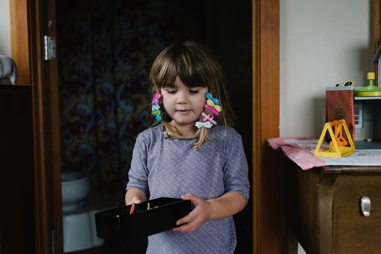 Young girl at home, wearing hair clips in hair