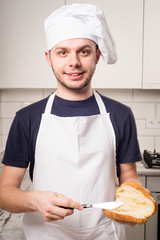 slile baker with peanut butter on a slice of croissant