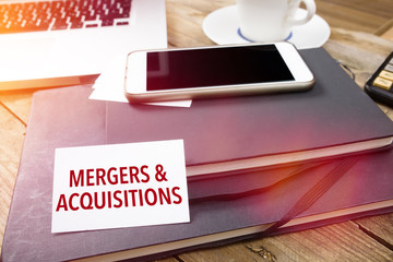Card with Mergers & Acquisitions text on office desktop