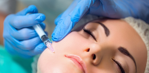 Obraz na płótnie Canvas Receiving mesotherapy procedure, cosmetology. Beautician doing procedure on woman. Skincare concept.
