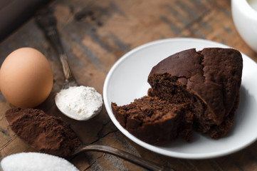 Cake, flour, sugar, cocoa, milk and eggs on a wooden table. Ingredients for cooking.