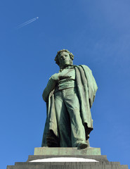 Monument to famous Russian poet Alexander Pushkin in Moscow (1880) and plane in sky