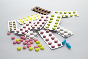 Pills of different colors on  light background