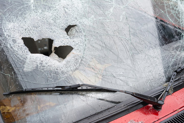 Close up of a broken car windshield smashed by a thief. Damaged glass from car theft