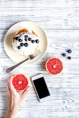 Breakfast concept with flowers on wooden background top view