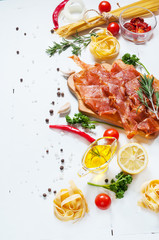 Background with pasta, tomatoes cherry and meat on white wooden table.