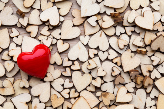 Wooden hearts, one red heart on the heart background.