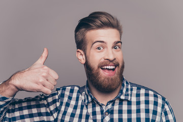 Young happy stylish bearded guy showing thumb up