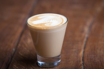 cappuccino in a glass on a wooden background