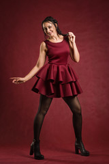 Beautiful  woman dressed in red dress in a vintage interior
