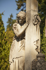 Fototapeta premium Woman on tomb as a symbol of depression and sorrow (antique stat