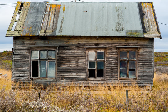 Old wooden decrepit house in need of repair with damaged roof and windows
